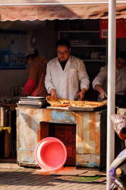 Çinli bir Asyalının Şangay, Çin 'deki bir markette pizza hazırlarken çekilmiş dikey bir fotoğrafı.