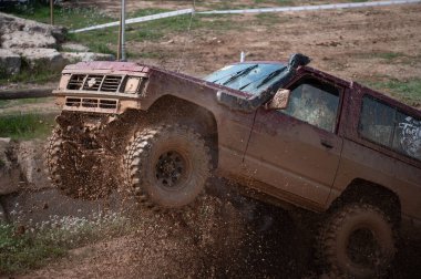 Kırmızı ikinci nesil Nissan devriyesi yoldan çıkıyor.