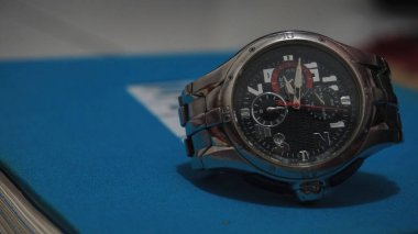 Modern bilek saatinin mavi bir kitaptaki yakın çekimi.