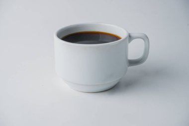 Beyaz arka planda izole edilmiş bir fincan sade kahvenin yakın çekimi.