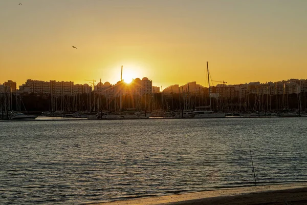 ビーチの建物の後ろの明るい夕日 — ストック写真