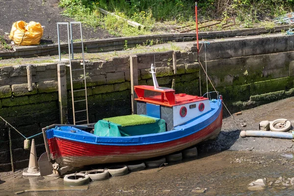 Küçük tekne Ouseburn nehrinde demirlemiş, Newcastle Tyne, İngiltere 'de, gelgitte.
