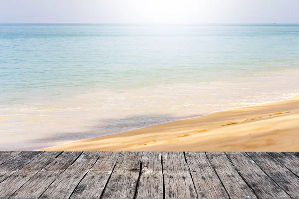 Güneşli bir günde verandadan görülen kumlu bir plajın mavi bir denize karşı üç boyutlu görüntüsü.
