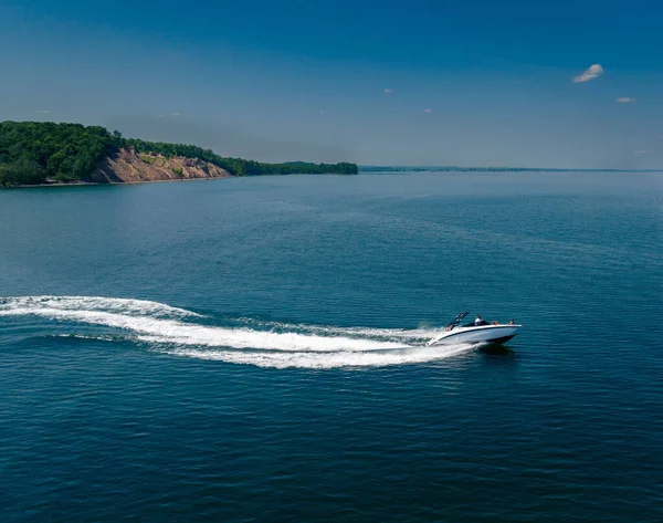 晴れた日にチムニー ブラフに対して青い海を航行するボートの空中ショット — ストック写真