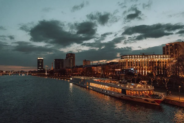 Karanlık gecede suyun yakınındaki modern binaların alçak açılı görüntüsü.