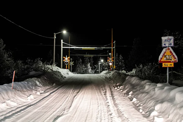 A view of snow covered railway surrounded by bushes in night