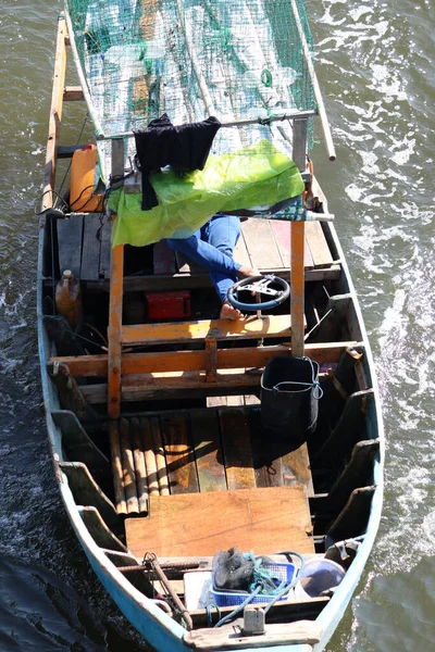 一个渔夫在港口的船上休息的垂直镜头 — 图库照片
