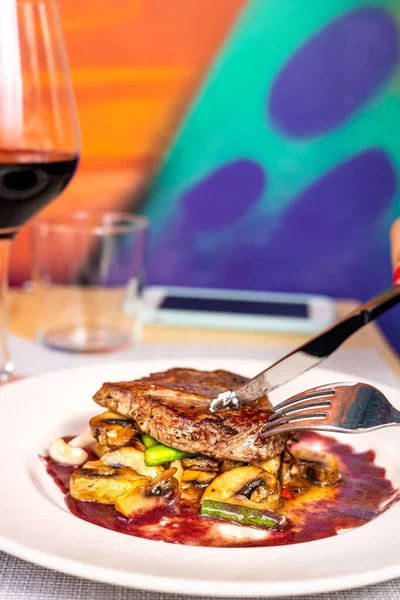 Bir sürü ızgara sebzenin doğrandığı bifteğin dikey görüntüsü.