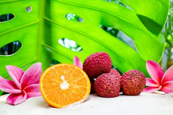 Vruchten Met Roze Plumeria Bloemen Het Zand Tegen Groen Tropisch — Stockfoto