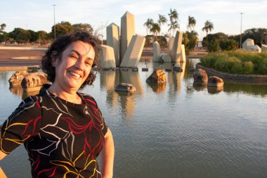 Güneşli bir günde parkta olgun bir bayan arka planda kristallerle eğleniyor.