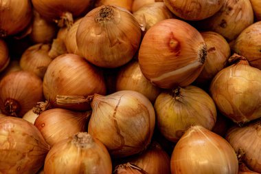 Bir avuç sarı soğanın yakın plan çekimi.