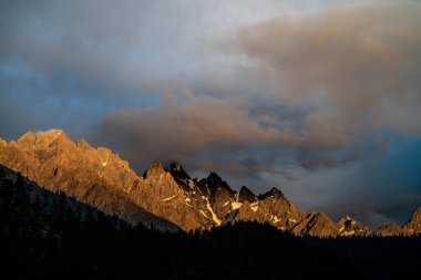 Dramatik bulutların altındaki dağların manzaralı manzarası