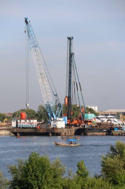 Önünde balıkçı teknesi olan bir vinç.