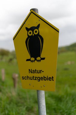 Almanya 'nın Ratzeburg kentindeki bir alanda sarı doğa koruma işaretinin dikey çekimi.