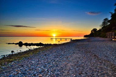 Baltık Denizi 'nde gün doğumu Timmendorfer Strand' da güzel bir gökyüzüyle
