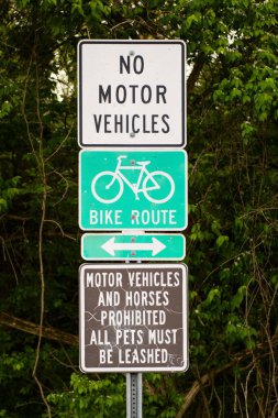 Ağaçlara ve çalılara karşı bisiklet güzergahı tabelasına yakın çekim