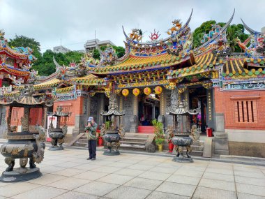 Taishan Up Temple, New Taipei City, Tayvan 'daki tapınağın girişinde bir adam içtenlikle dua ediyor.