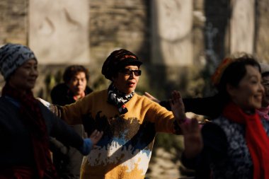 Şangay halkı güneşli bir günde sokaklarda dans ediyor.