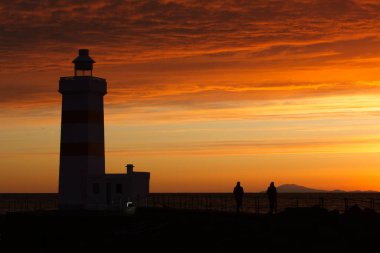 Sambro Adası Deniz feneri yakınlarında gün batımının keyfini çıkaran iki kişinin güzel bir fotoğrafı.