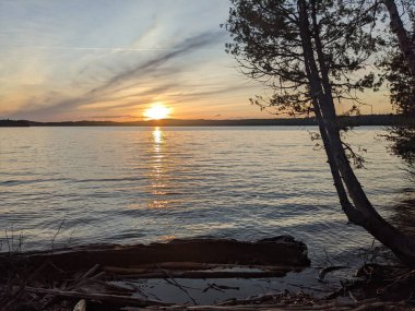 Parlak gün batımının huzurlu manzarası bir gölün üzerinde
