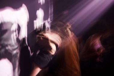 Şangay 'daki bir gece kulübünde mor ışıkla dans eden insanların bulanık bir fotoğrafı.