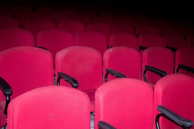 Tiyatroda boş kırmızı sandalyeler. Fotoğraf el feneri kullanılarak çekildi.