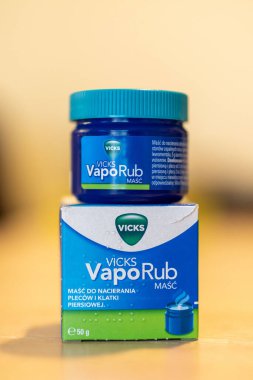 Bir kutu içinde Vicks VapoRub cilt kremi ve masada kavanoz.