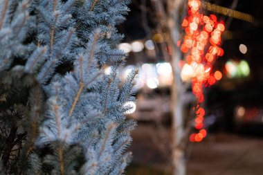Bokeh arka planına karşı beyaz bir Noel ağacının seçici odak noktası