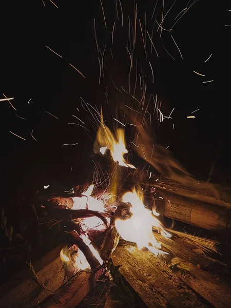 暗闇の中の木のたき火を火花が飛んで — ストック写真