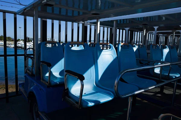 Yan yana park etmiş mavi koltuklu bir tur otobüsü.