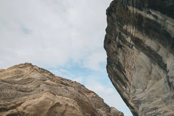 Bulutlu gökyüzüne karşı geniş kaya oluşumlarının alçak açısı