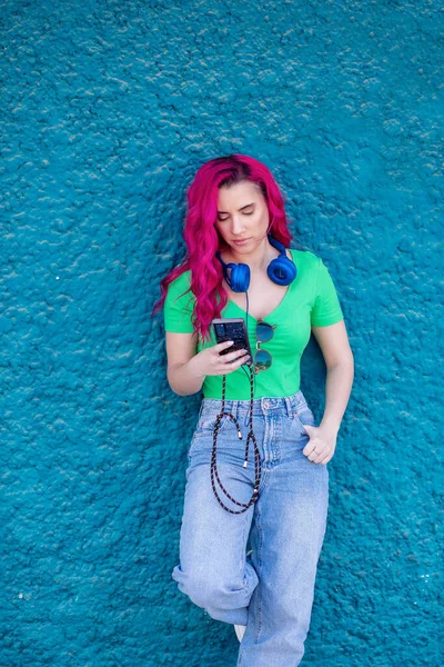 Вертикальний Знімок Красивої Молодої Дівчини Рожевим Волоссям Навушниками Синій Текстурованій — стокове фото