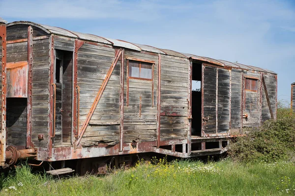 rusty and damaged train carriages at an abandoned train station