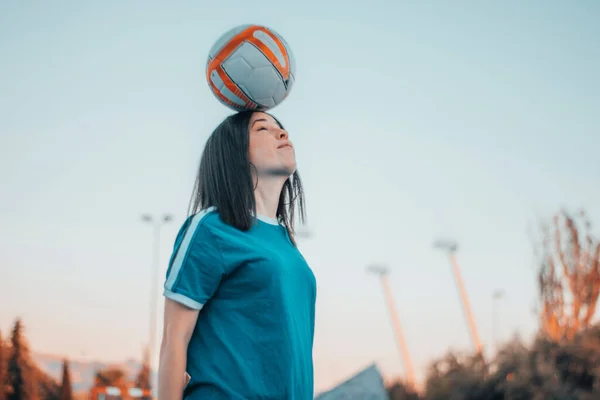 美しい女性がサッカーをして頭でボールを打つ — ストック写真