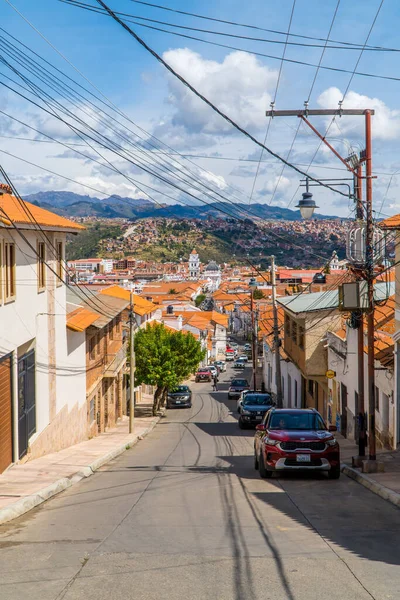 Sucre, Bolivya 'da bulutlu bir gökyüzüne karşı evler ve elektrik kabloları arasında dar bir sokak.