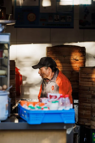 中国のカウンターの後ろに立っている男の垂直ショット — ストック写真