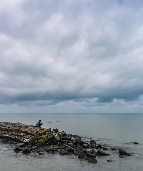 Ένας Άντρας Μόνος Που Ψαρεύει Στην Παραλία Πάνω Ένα Συννεφιασμένο — Φωτογραφία Αρχείου