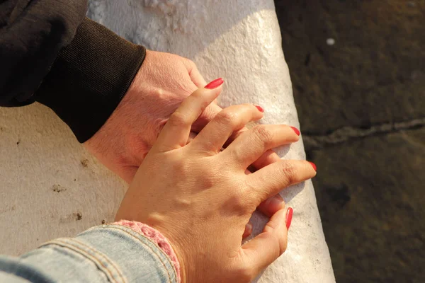 Närbild Ett Par Som Håller Varandras Händer Vägg Bakgrund — Stockfoto