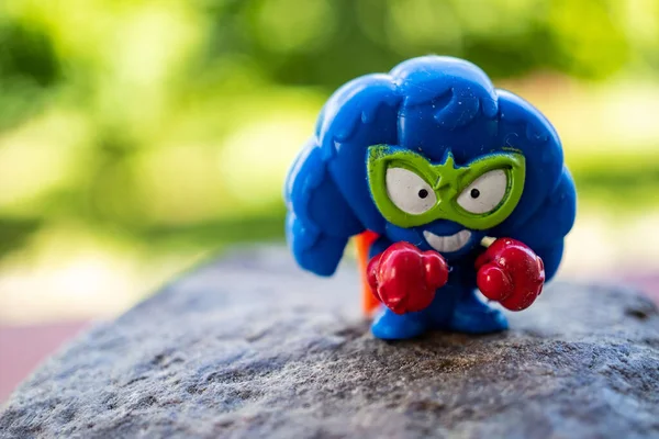 Bir kayanın üzerinde duran kahraman takımından mavi bir kruvasan oyuncağı.