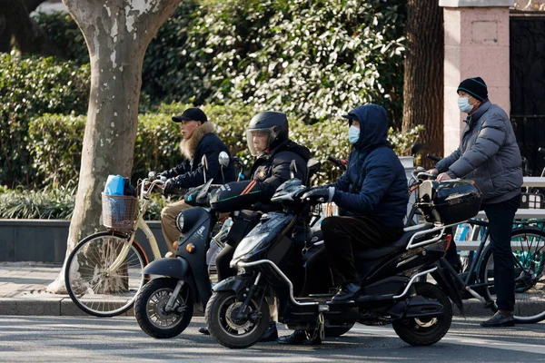 一些中国人在上海的大街上骑摩托车 — 图库照片
