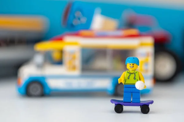 Figurka Człowieka Lego Kaskiem Stojącym Deskorolce Blisko Furgonetki Lodami — Zdjęcie stockowe
