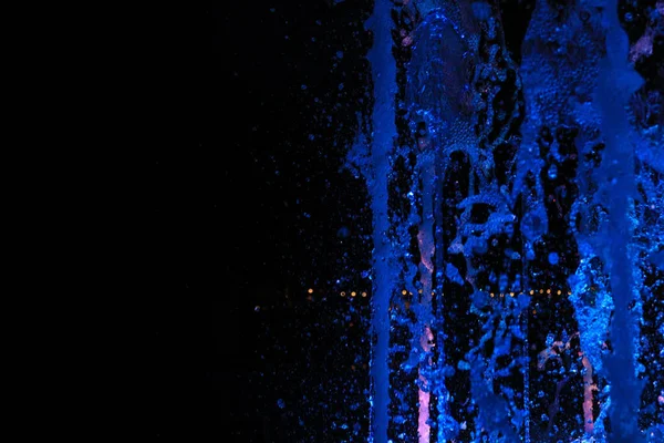 Mavi Tonlu Bir Çeşmeden Aydınlatılmış Suyun Yakın Çekimi — Stok fotoğraf