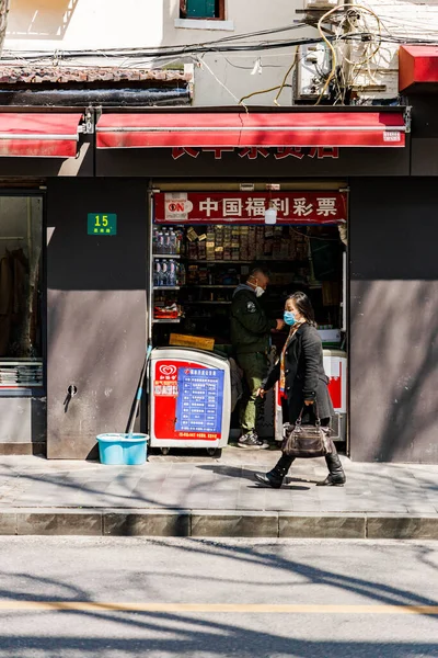 Függőleges Felvétel Egy Nőről Orvosi Maszkban Amint Járdán Sétál Sanghajban — Stock Fotó