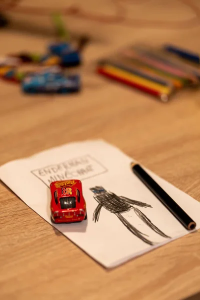 Minecraftの図面とテーブルの上に赤いマッテル ライトニング マックイーンのおもちゃの車からエンダーマンの図面 — ストック写真
