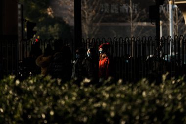 Arka planında metal çitler olan Şangay halkı.