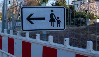 Sokaktaki yayaları gösteren bir uyarı levhası.