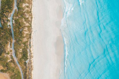 Mavi denizli, cennet gibi beyaz kumlu bir sahilin havadan görünüşü.