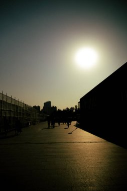 Çin, Şangay 'da insanların yaşadığı ve güneşin altında siluetler inşa ettiği kentsel bir sahnenin dikey çekimi.