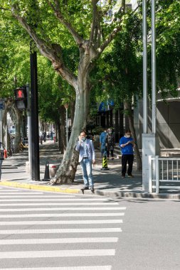 Çin 'in Şangay caddesinde hayatlarına devam eden insanların dikey görüntüsü.