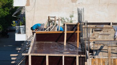 İnşaat işçileri gün içinde, Volos, Yunanistan, 6-3-2022 vakıfları için demir sütunlar inşa etmek için çalışıyorlar